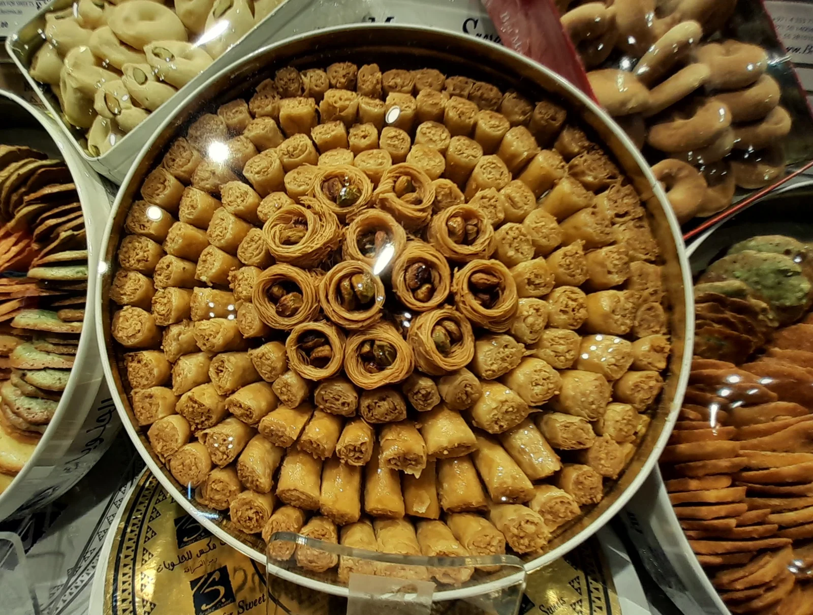 Fıstıklı baklava dilimlerinin kutuda daire şeklinde dizilmiş hâli