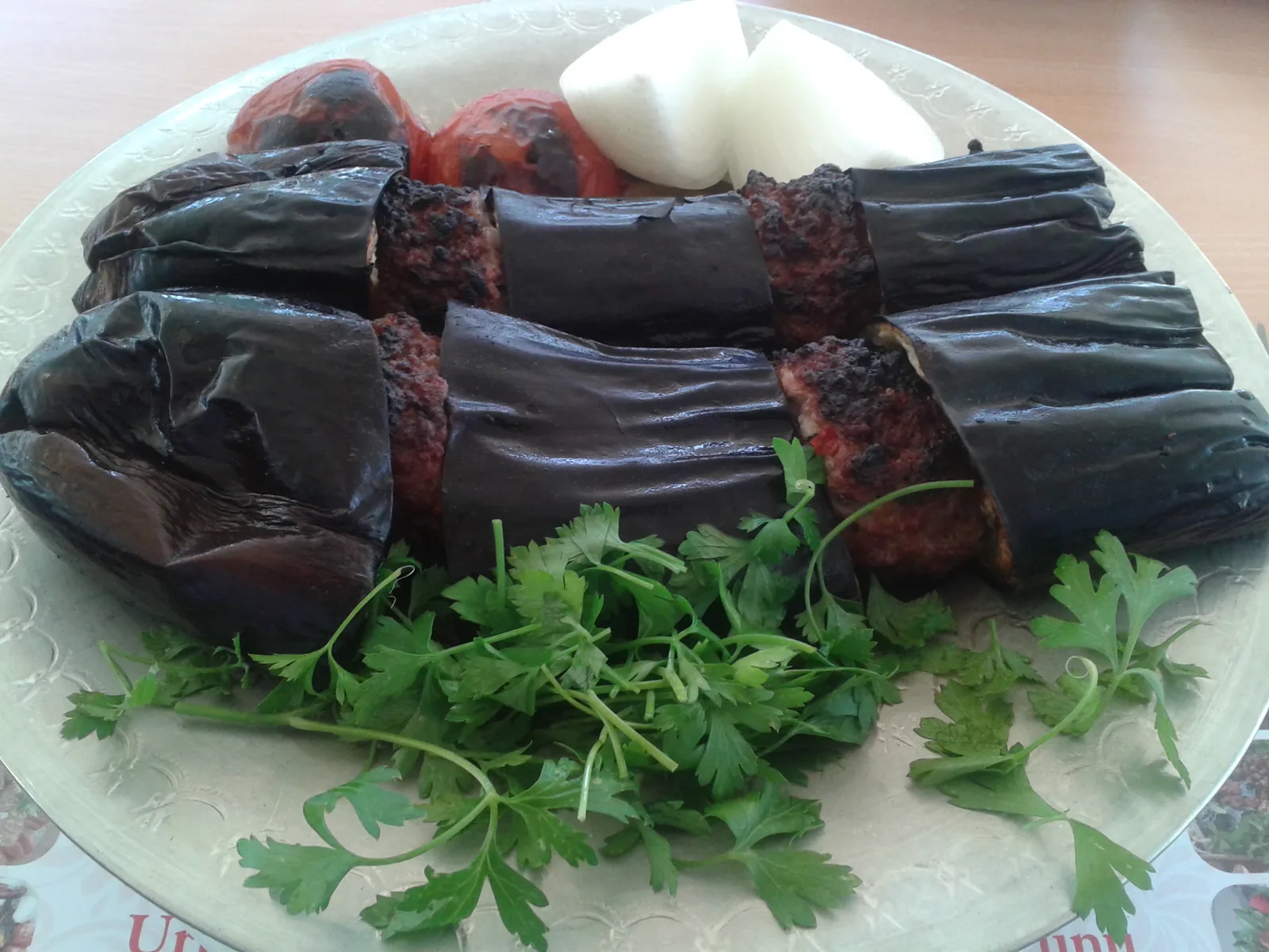 Fırın tepsisinde patlıcan dilimleri ve köftelerle hazırlanmış kebap
